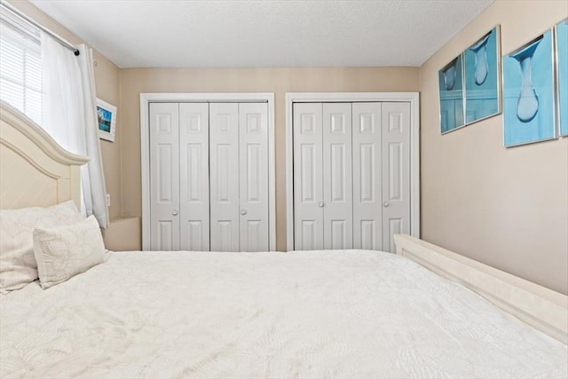 bedroom featuring two closets and a textured ceiling