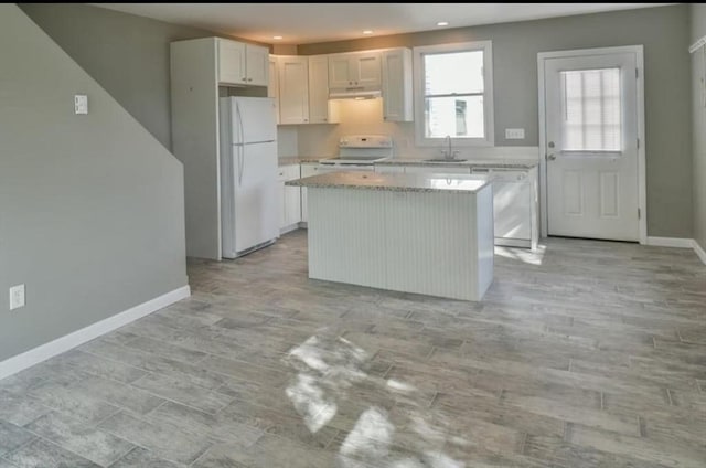 6 Rio, Gloucester, MA 01930 - kitchen featuring white appliances, a center island, under cabinet range hood, recessed lighting, and light stone countertops