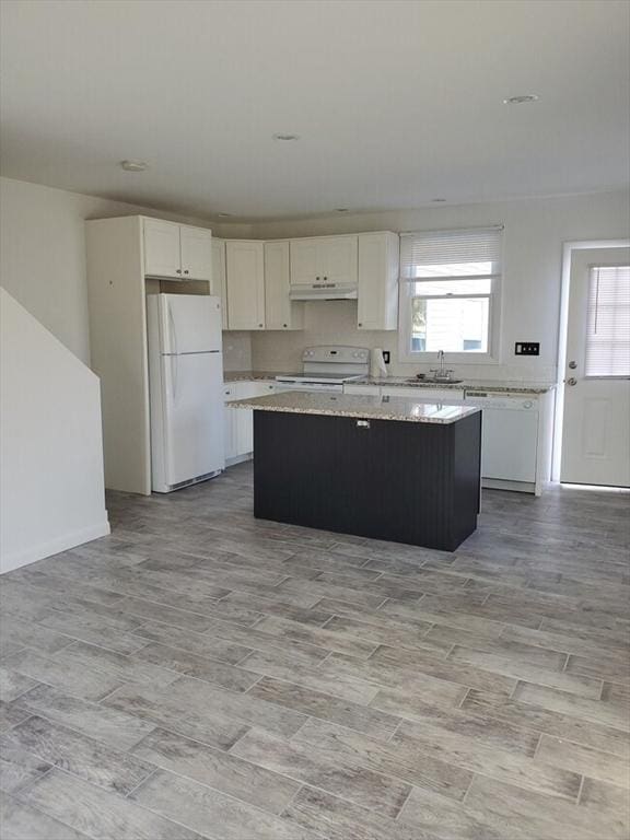 6 Rio, Gloucester, MA 01930 - kitchen featuring white appliances, under cabinet range hood, a center island, and white cabinets