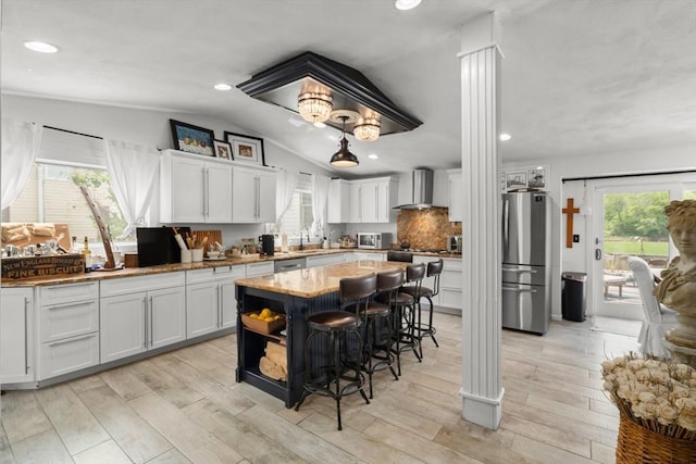 6 Rio, Gloucester, MA 01930 - kitchen with appliances with stainless steel finishes, wall chimney range hood, white cabinetry, a kitchen island, and a kitchen breakfast bar