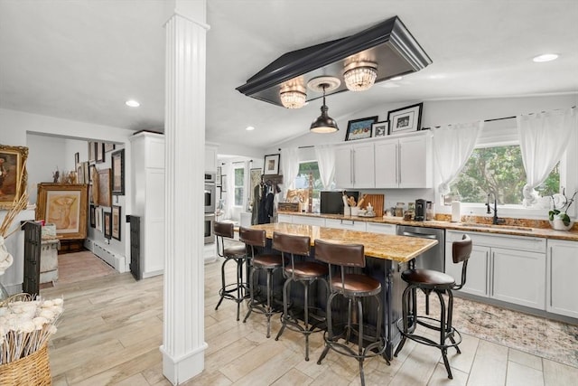 6 Rio, Gloucester, MA 01930 - kitchen featuring stainless steel appliances, a breakfast bar, lofted ceiling, a kitchen island, and decorative columns