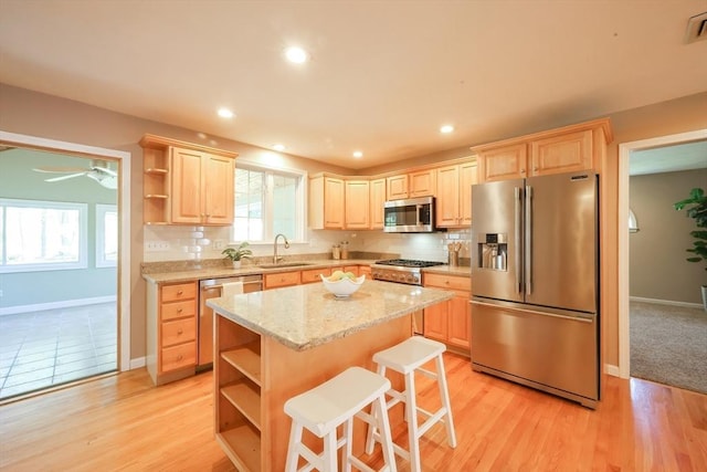 kitchen featuring open shelves, appliances with stainless steel finishes, a sink, and light brown cabinets