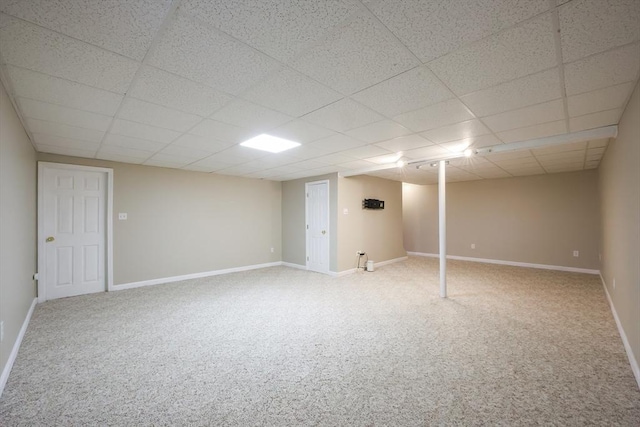 finished basement with baseboards, carpet flooring, and a paneled ceiling