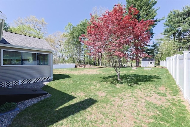 view of yard featuring a storage unit, a fenced backyard, and an outdoor structure