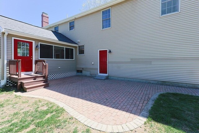 rear view of house with a patio and a chimney