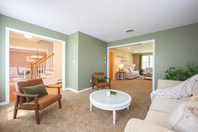 living area featuring a baseboard heating unit, an inviting chandelier, carpet, and visible vents