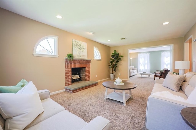 carpeted living room featuring baseboards, a brick fireplace, recessed lighting, and visible vents