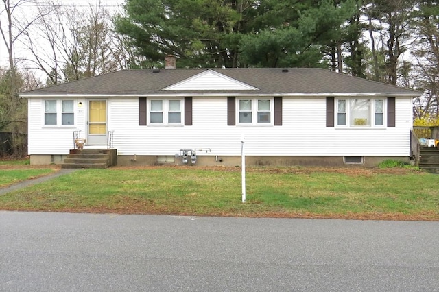 ranch-style house with roof with shingles, a chimney, and a front yard