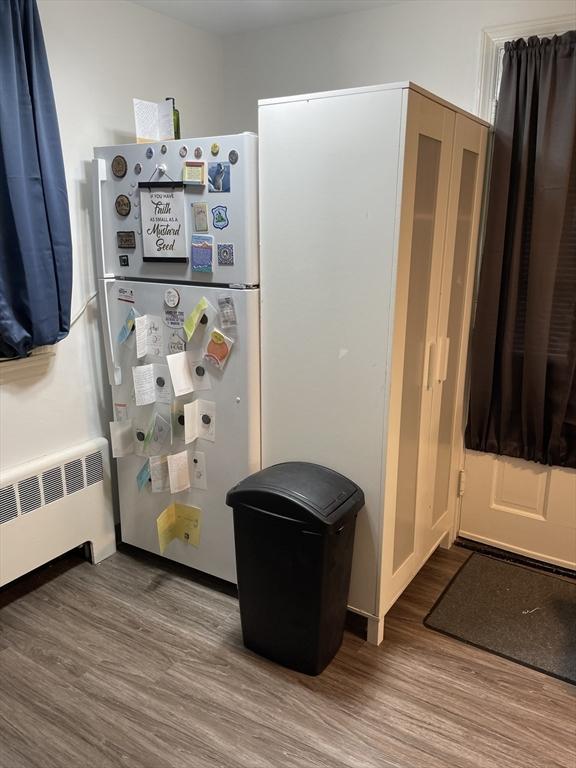 interior space with radiator heating unit and wood finished floors