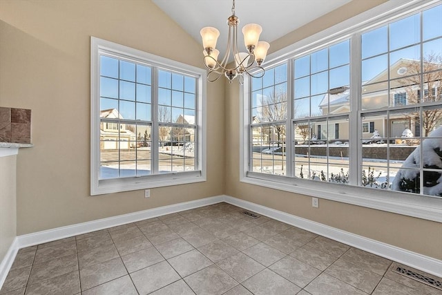 unfurnished dining area with a notable chandelier, tile patterned floors, and lofted ceiling