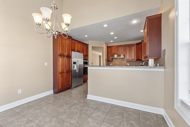 kitchen with stainless steel refrigerator with ice dispenser, decorative light fixtures, backsplash, light tile patterned floors, and light stone counters