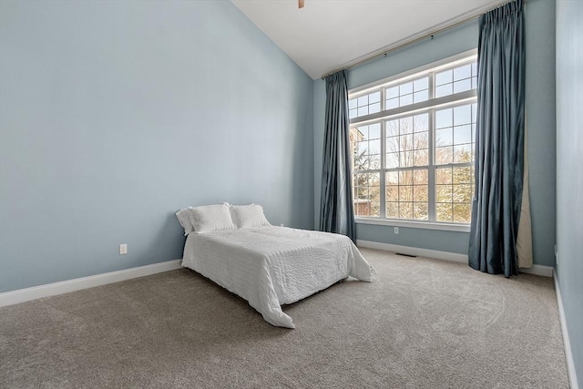 bedroom with multiple windows, light carpet, and lofted ceiling