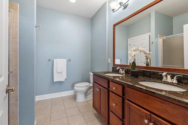 bathroom featuring vanity, toilet, an enclosed shower, and tile patterned flooring