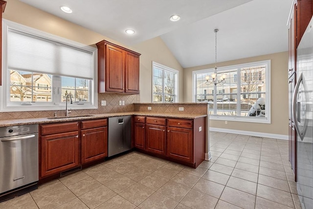 kitchen featuring pendant lighting, dishwasher, lofted ceiling, sink, and light tile patterned flooring