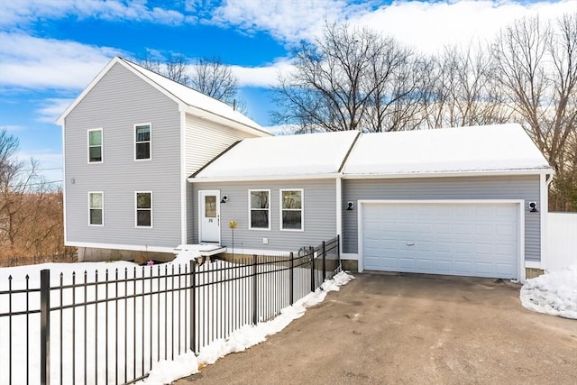 traditional-style home with a garage, driveway, and fence