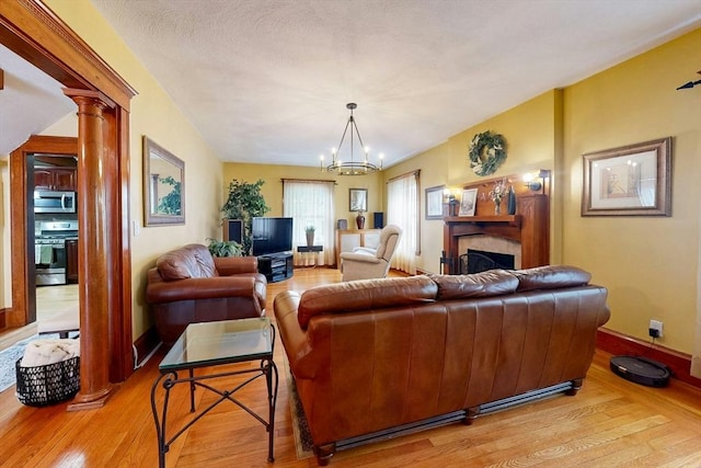 19 Orlando Ave, Winthrop, MA 02152 - living area featuring light wood-type flooring, ornate columns, a chandelier, a fireplace, and baseboards