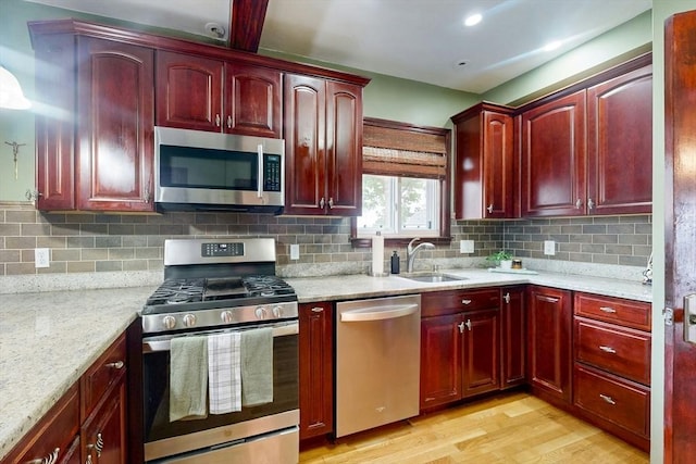 19 Orlando Ave, Winthrop, MA 02152 - kitchen with stainless steel appliances, dark brown cabinets, a sink, and light wood-style flooring