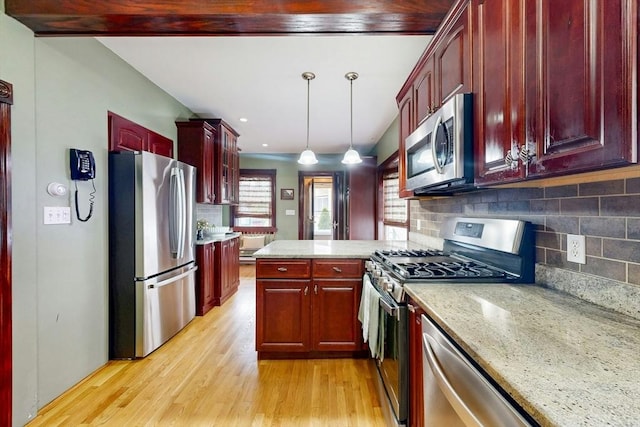 19 Orlando Ave, Winthrop, MA 02152 - kitchen with appliances with stainless steel finishes, dark brown cabinets, light wood-type flooring, decorative backsplash, and hanging light fixtures