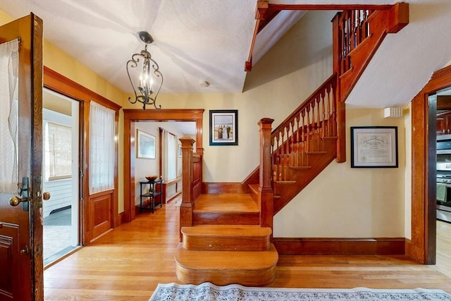 19 Orlando Ave, Winthrop, MA 02152 - entrance foyer with wood finished floors, baseboards, stairway, a chandelier, and vaulted ceiling
