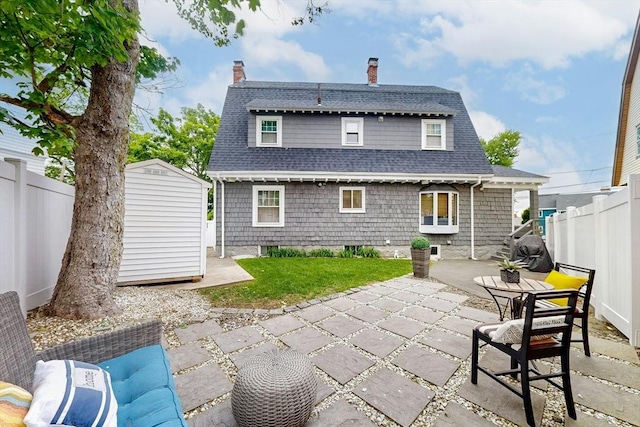 19 Orlando Ave, Winthrop, MA 02152 - back of house featuring a patio area, a chimney, a fenced backyard, and roof with shingles