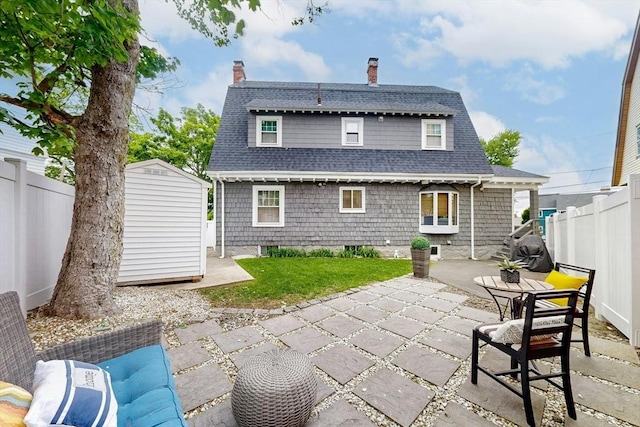 19 Orlando Ave, Winthrop, MA 02152 - rear view of house featuring a patio, a chimney, a fenced backyard, and a shingled roof