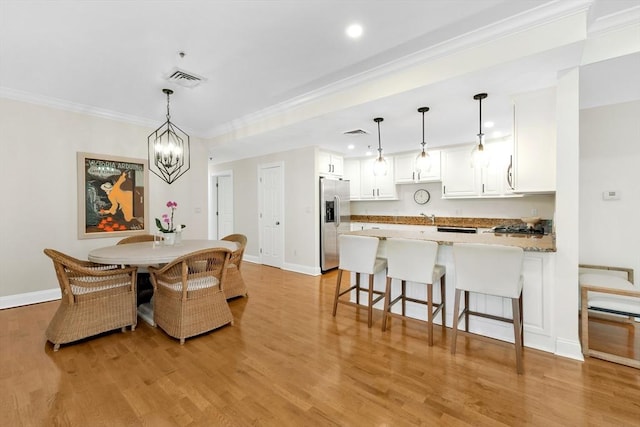 95 Conant St Unit 404, Concord, MA 01742 - dining space with baseboards, light wood-type flooring, crown molding, recessed lighting, and a chandelier
