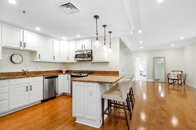 95 Conant St Unit 404, Concord, MA 01742 - kitchen featuring stainless steel appliances, light wood-style floors, white cabinetry, a sink, and recessed lighting