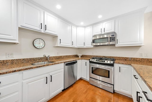 95 Conant St Unit 404, Concord, MA 01742 - kitchen with stainless steel appliances, a sink, white cabinetry, light wood-type flooring, and stone counters
