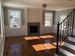 41 Rustic Dr, Worcester, MA 01609 - unfurnished living room with stairway, a fireplace with flush hearth, plenty of natural light, wood finished floors, and wainscoting