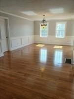 41 Rustic Dr, Worcester, MA 01609 - unfurnished dining area featuring wood finished floors, a wainscoted wall, and a decorative wall