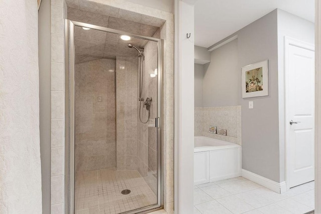 full bathroom featuring baseboards, a shower stall, a garden tub, and tile patterned floors