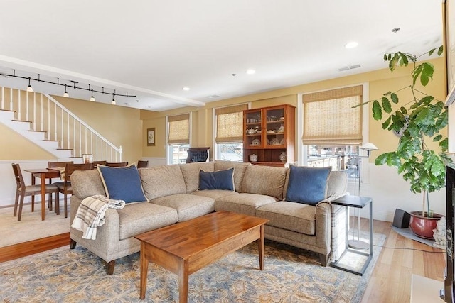 living area featuring recessed lighting, visible vents, rail lighting, stairway, and wood finished floors