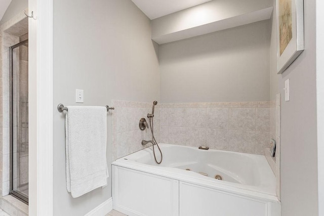 full bathroom featuring a jetted tub and a shower stall