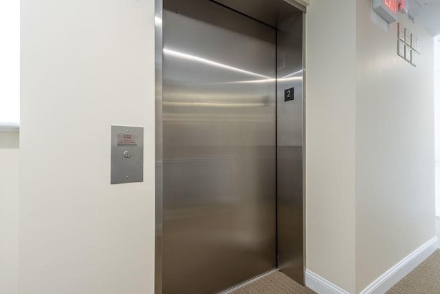 interior details featuring elevator and baseboards