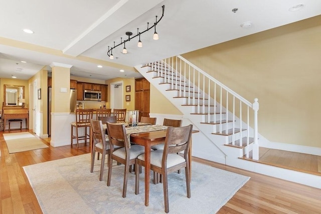 dining space with light wood-style flooring, recessed lighting, baseboards, stairway, and track lighting