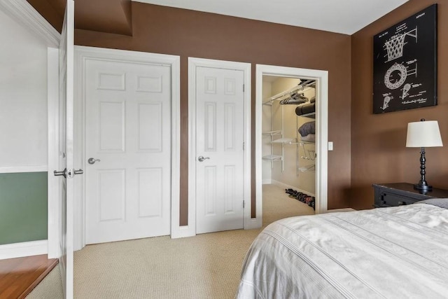 bedroom featuring carpet flooring, baseboards, a closet, and a spacious closet