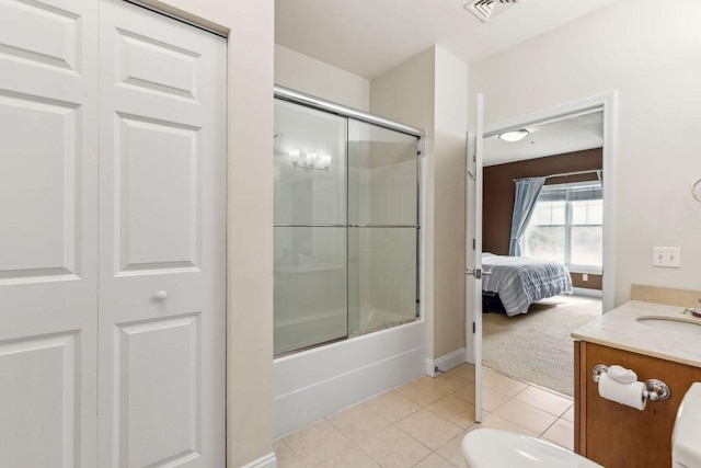 ensuite bathroom featuring tile patterned floors, vanity, shower / bath combination with glass door, and baseboards