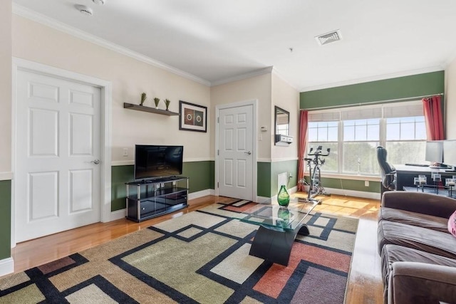 living room with ornamental molding, wood finished floors, and baseboards