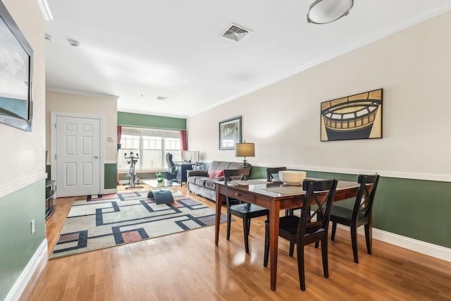 dining area featuring ornamental molding, wood finished floors, and baseboards