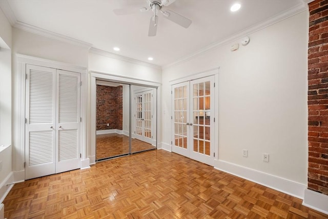 unfurnished bedroom featuring french doors, two closets, brick wall, baseboards, and ornamental molding