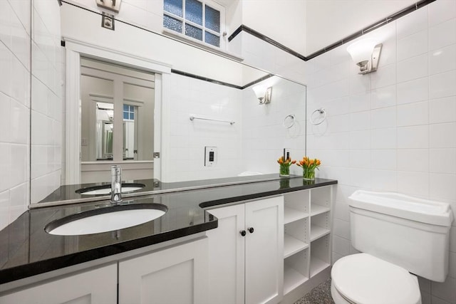 bathroom with tile walls, toilet, and vanity