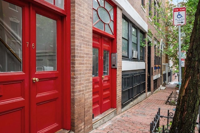 doorway to property featuring french doors and brick siding