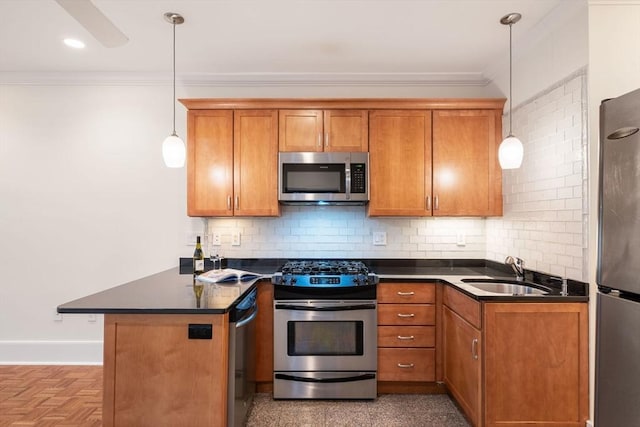 kitchen with appliances with stainless steel finishes, crown molding, brown cabinets, a sink, and dark countertops