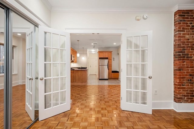 corridor with french doors, crown molding, and baseboards