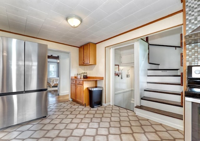 108 Needham St, Dedham, MA 02026 - kitchen with appliances with stainless steel finishes, brown cabinets, ornamental molding, light countertops, and baseboards