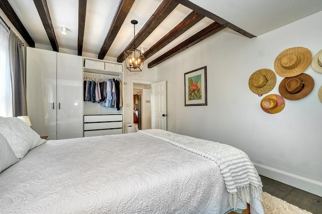 108 Needham St, Dedham, MA 02026 - bedroom with wood finished floors, baseboards, beam ceiling, a closet, and a chandelier