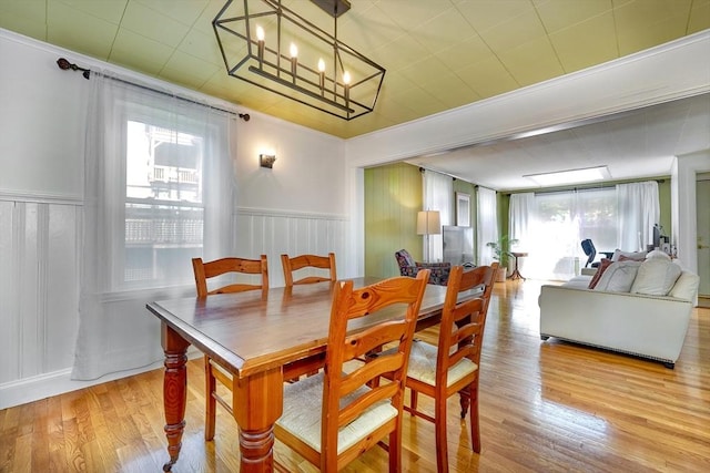 108 Needham St, Dedham, MA 02026 - dining room featuring plenty of natural light, light wood-style floors, a wainscoted wall, and a chandelier