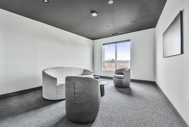 living area with baseboards and carpet