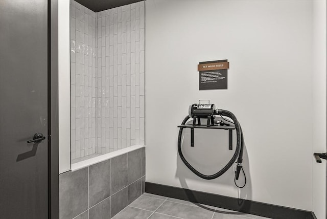 bathroom featuring tile patterned floors, baseboards, and tiled shower