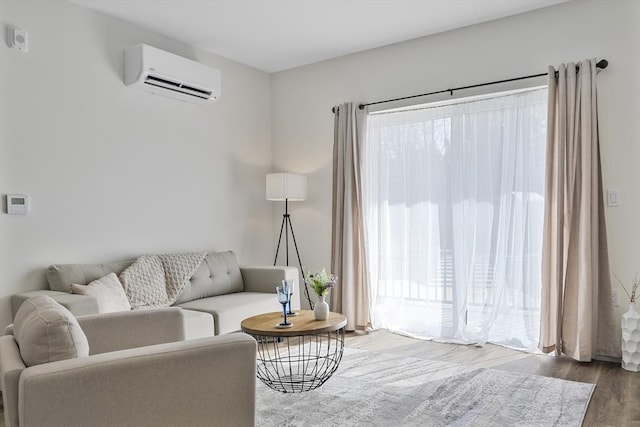 living area with a wall mounted air conditioner and wood finished floors